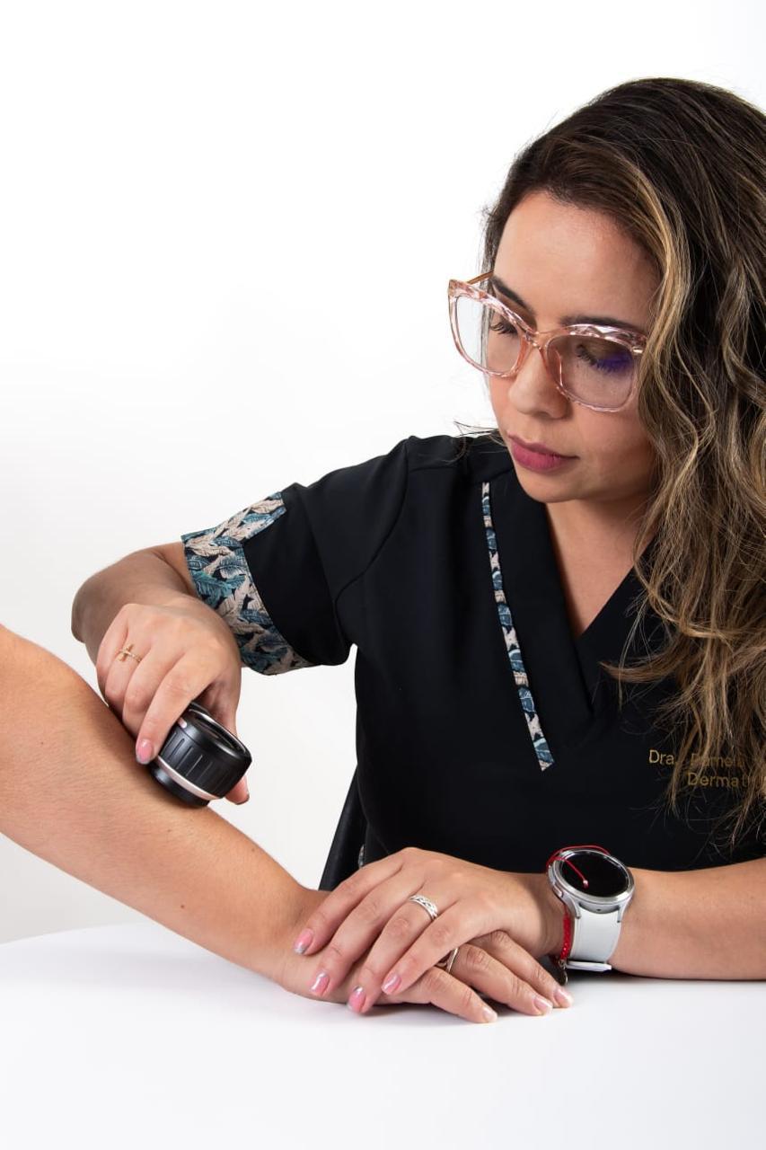 Dermatóloga de Clínica Leben evaluando la piel del antebrazo con dermatoscopio